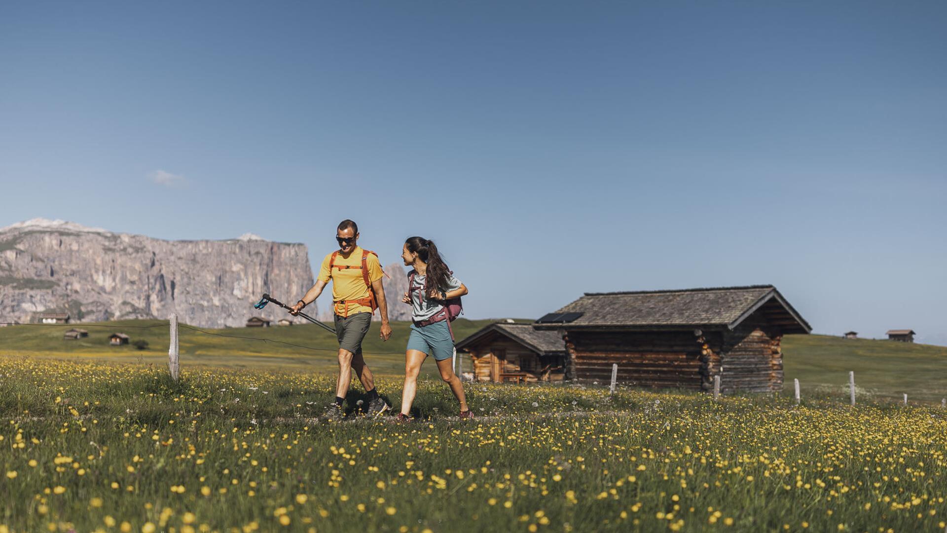 Ein Mann und eine Frau beim Wandern auf der Seiser Alm im Frühling