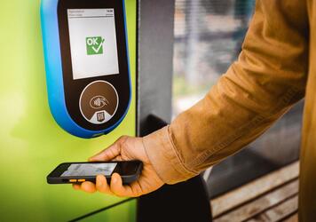 Ein Mann liest seine Fahrkarte ab