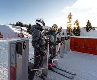 Ein Mann und eine Frau passieren die Schranke am Skilift