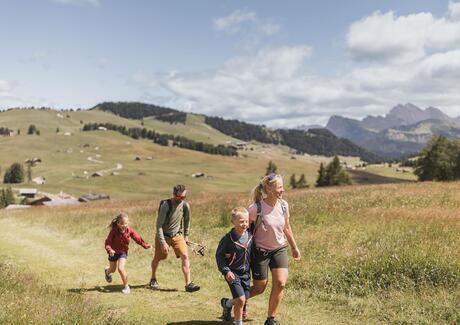 Eine Familie mit zwei Kindern beim Wandern auf der Seiser Alm