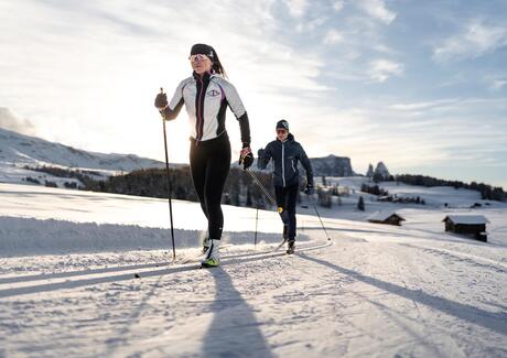 Two people are cross-country skiing on the Seiser Alm