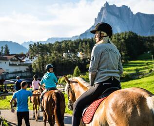 Eine Gruppe von Personen reitet auf Pferden