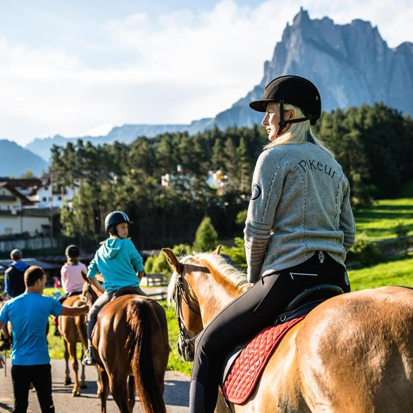 Eine Gruppe von Personen reitet auf Pferden