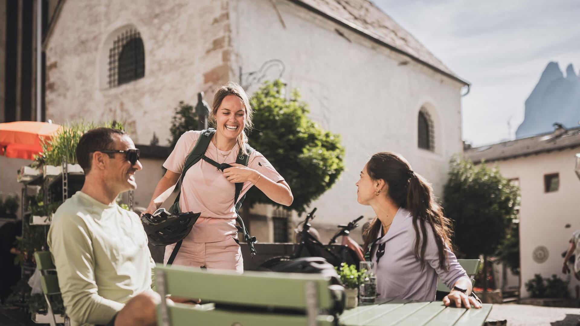 Drei Personen sitzen an einem Tisch und trinken Kaffee