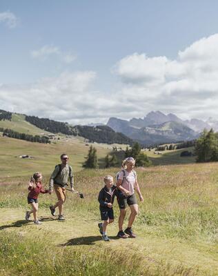Eine Familie mit zwei Kindern beim Wandern auf der Seiser Alm