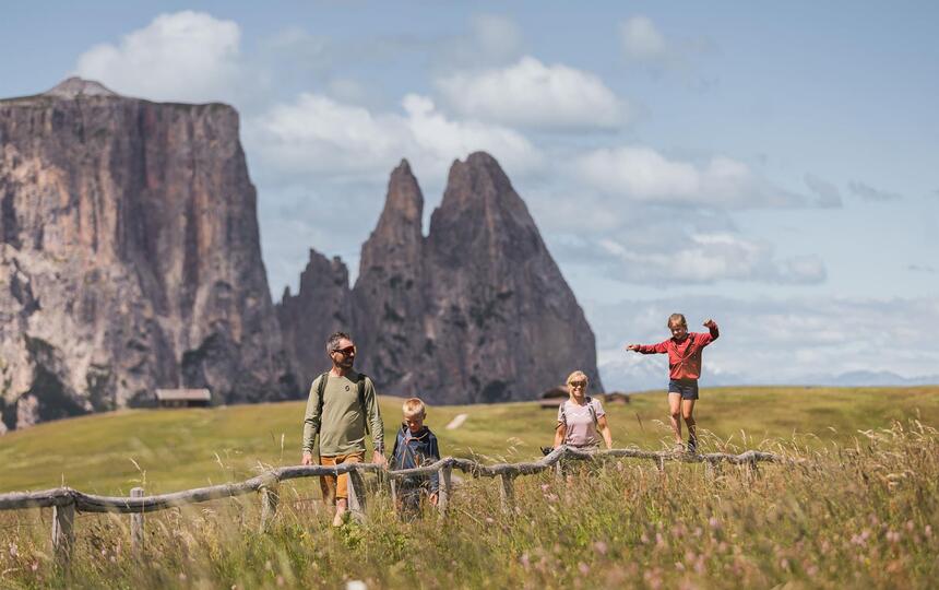 Eine Familie mit zwei Kindern beim Wandern auf der Seiser Alm