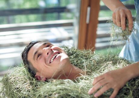 Ein Mann liegt im Heubad