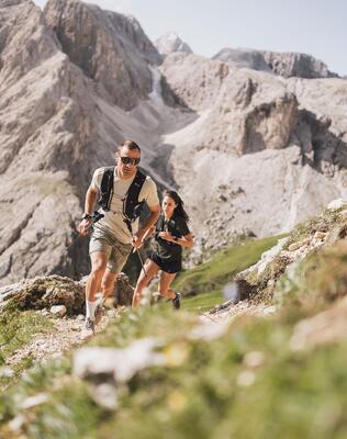 Ein Mann und eine Frau beim Trailrun auf der Seiser Alm