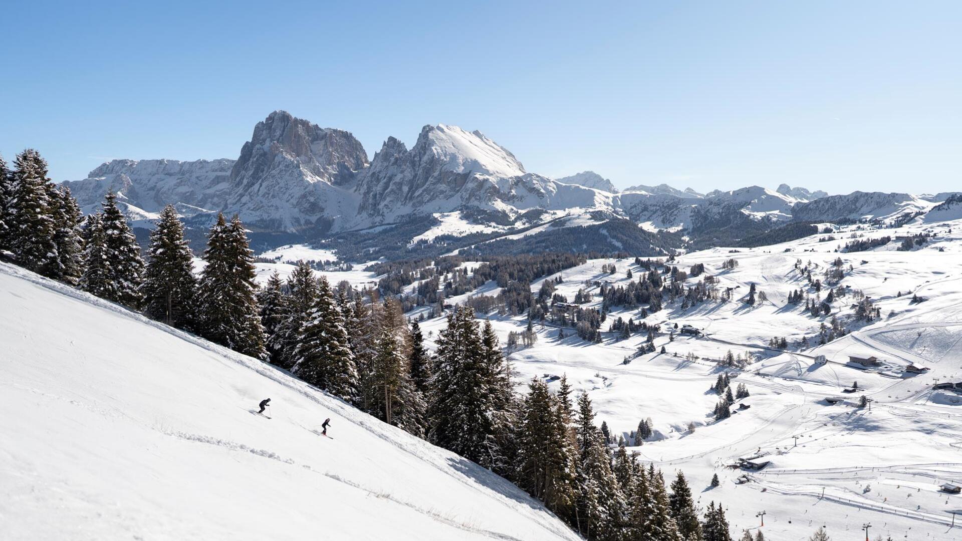 Ein Mann und eine Frau fahren eine Skipiste hinunter