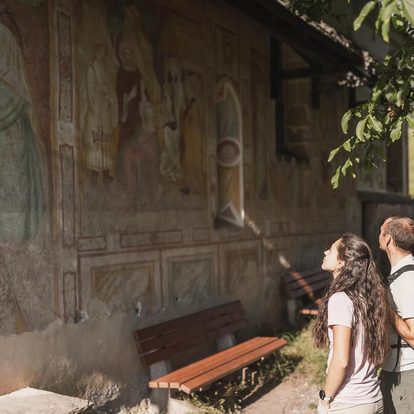 Ein Mann und eine Frau blicken auf Fresken