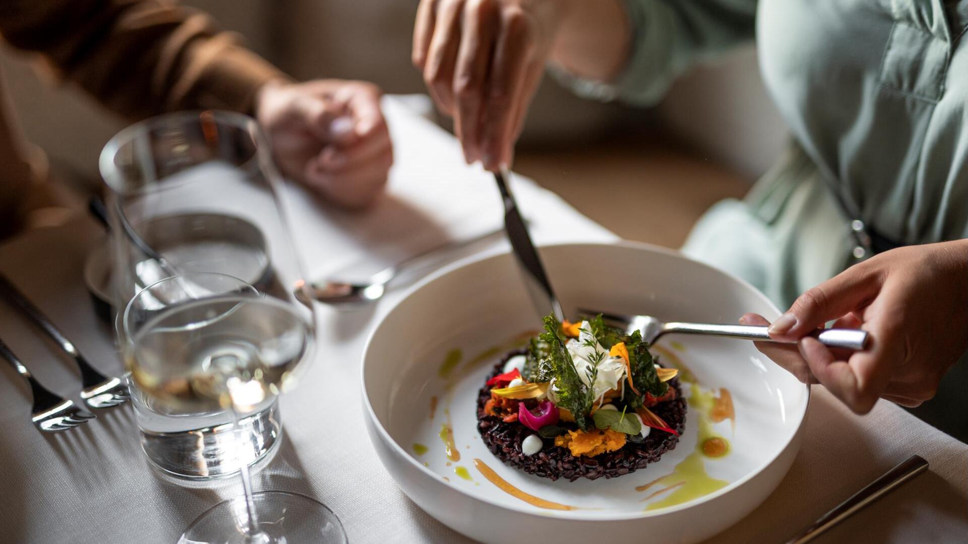 Eine Person isst einen fein angerichteten Risotto