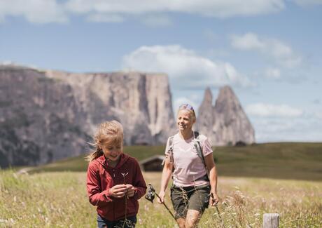 Eine Frau und ein Mann wandern auf der Seiser Alm