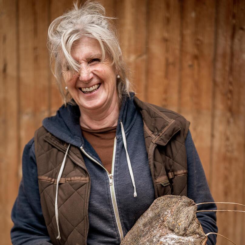 Eine Frau hält ein Stück Speck dabei