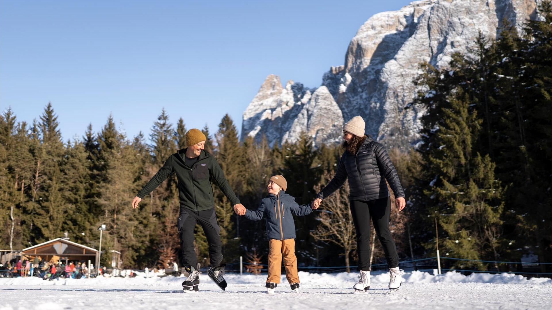 Eine Familie mit einem Kind läuft Schlittschuh