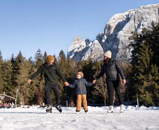 Eine Familie mit einem Kind läuft Schlittschuh