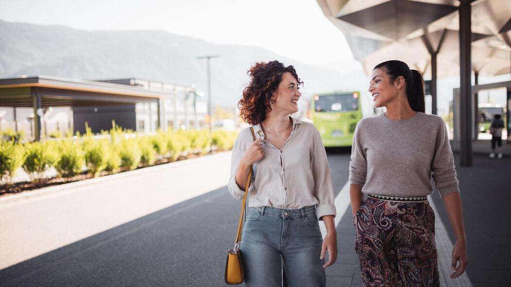 Zwei Frauen an einem Busbahnhof
