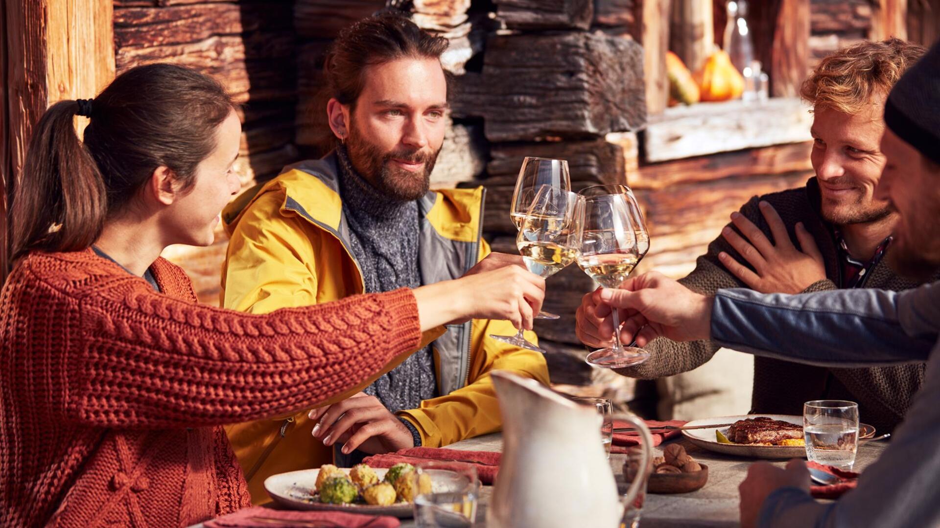 Eine Gruppe von Personen beim Anstoßen mit einem Glas Wein