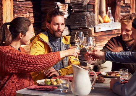 Eine Gruppe von Personen beim Anstoßen mit einem Glas Wein