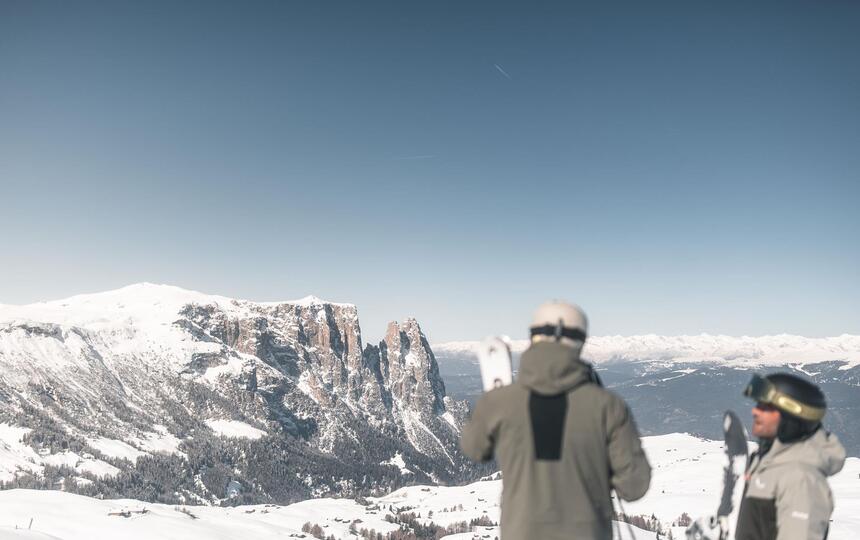 Zwei Männer in Skiausrüstung blicken auf den Schlern