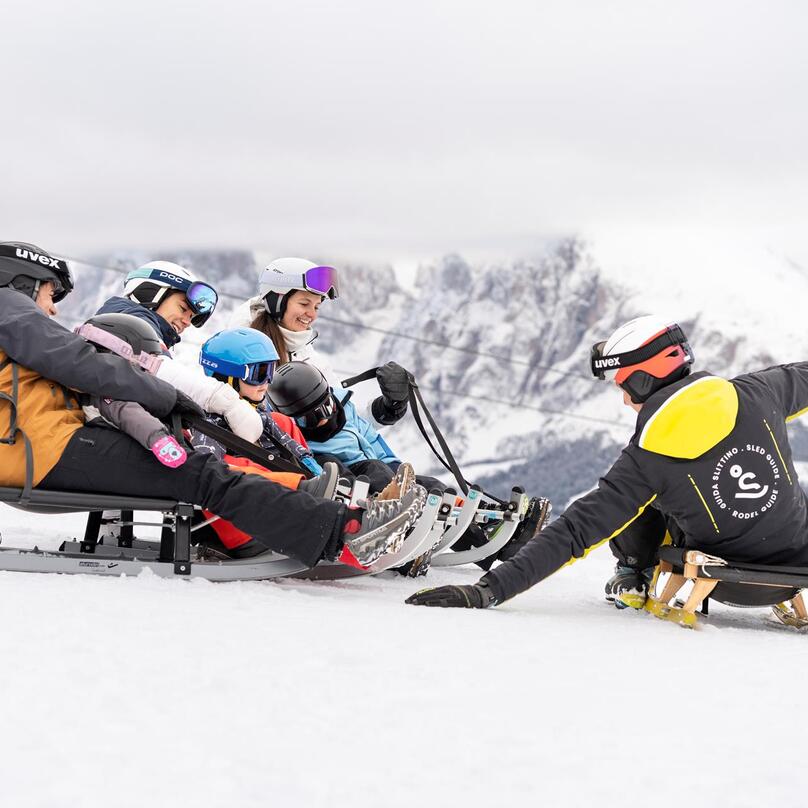 Eine Gruppe von Personen beim Rodeln im Winter