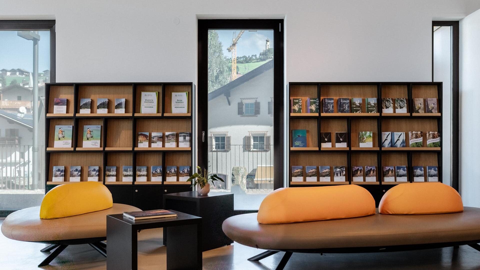 Nel locale ci sono dei divani e sullo sfondo si trovano numerosi libri sugli scaffali