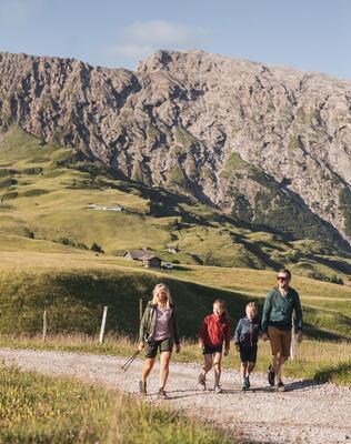 ine Familie mit zwei Kindern unterwegs auf der Seiser Alm.
