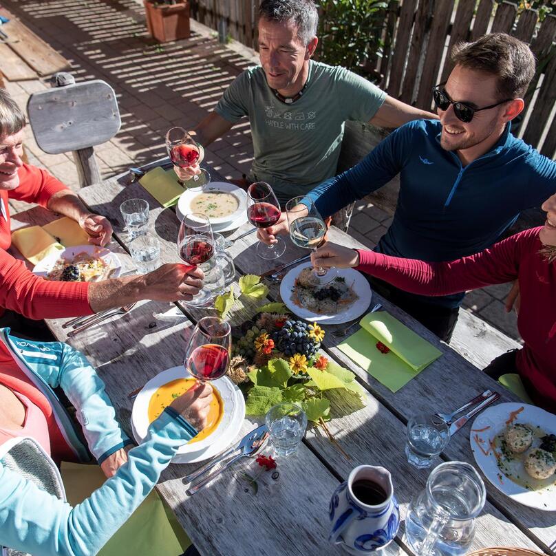 Un gruppo di persone è seduto insieme a un tavolo e mangia