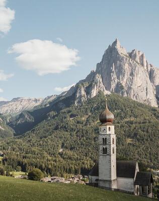 Chiesa parrocchiale di Siusi allo Sciliar, con le Dolomiti sullo sfondo
