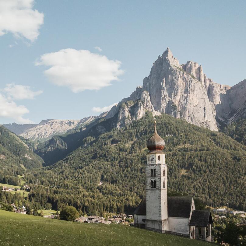 Chiesa parrocchiale di Siusi allo Sciliar, con le Dolomiti sullo sfondo