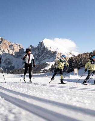 Eine Familie mit zwei Kindern beim Langlaufen auf der Seiser Alm