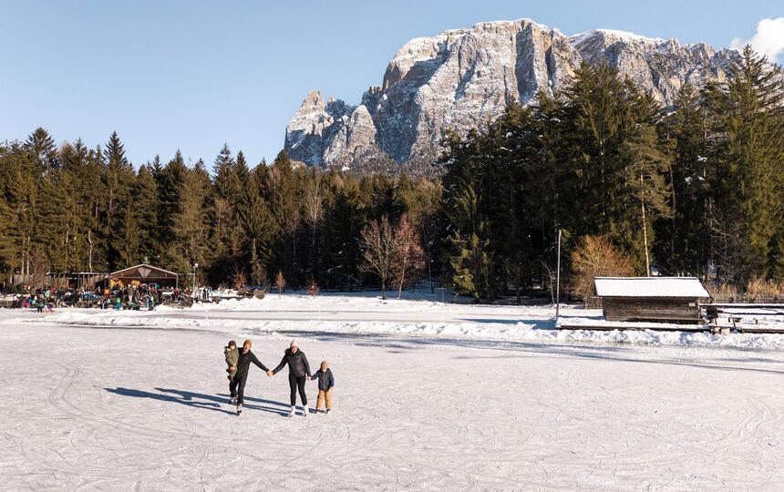 Eine Familie mit zwei Kindern läuft Schlittschuh