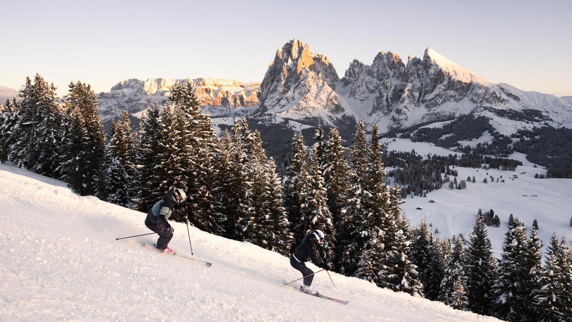 Ein Mann und eine Frau fahren eine Skipiste hinunter