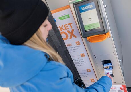 Eine Frau kauft eine Dolomiti Superski Karte