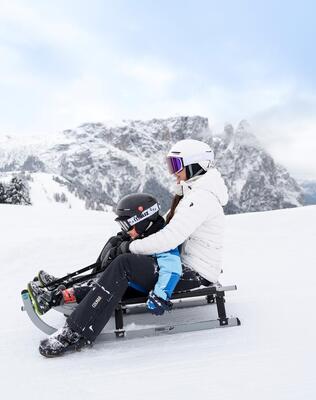 Eine Frau und ein Kind beim rodeln