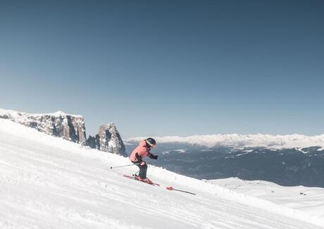 Eine Frau fährt eine Skipiste hinunter