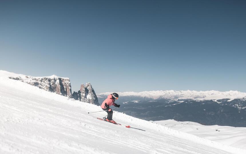 Eine Frau fährt eine Skipiste hinunter