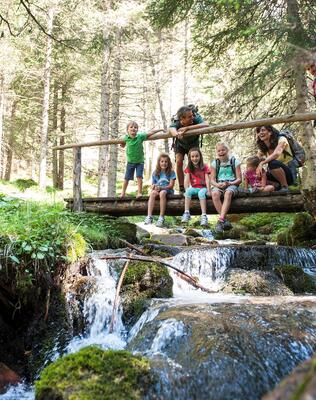Eine Familie sitzt auf einer Holzbrücke im Wald