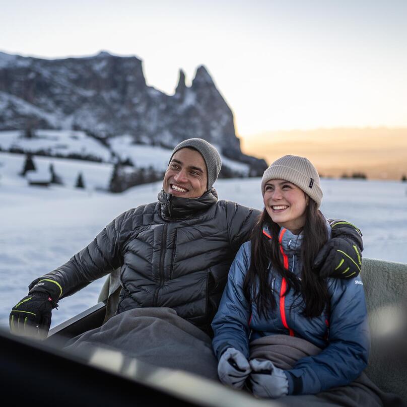 Ein Mann und eine Frau sitzen in einer Pferdekutsche