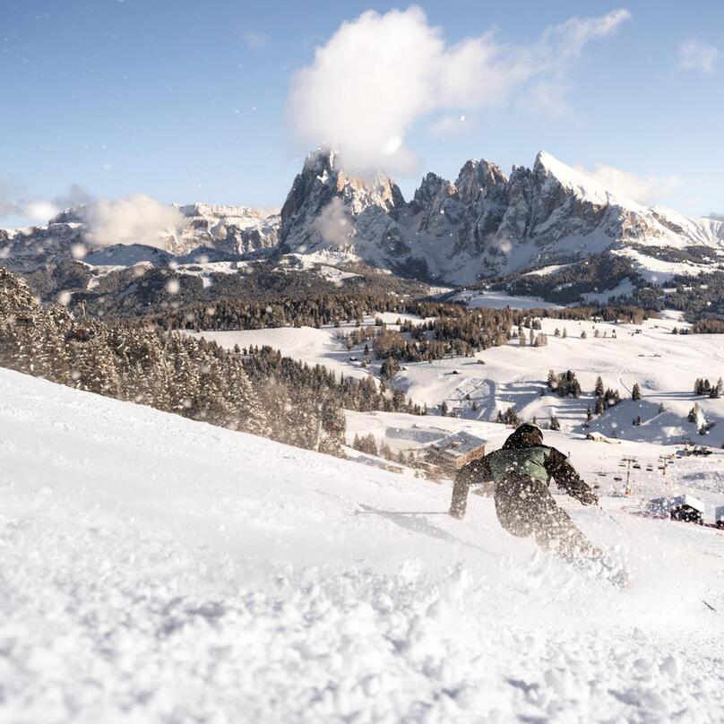 Ein Mann fährt eine Skipiste hinunter