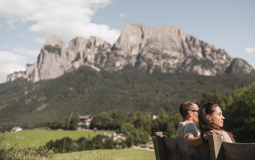 Ein Mann und eine Frau sitzen auf einer Holzbank