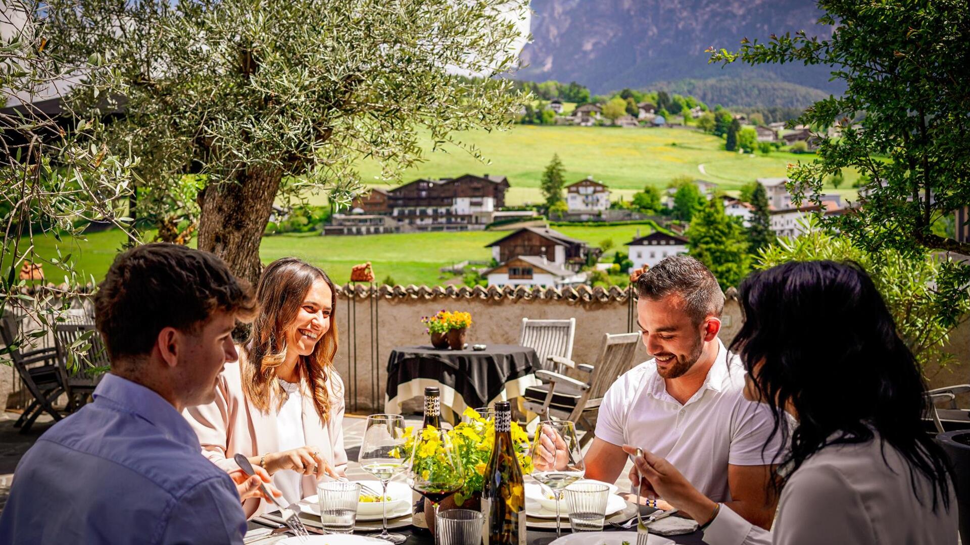 Due uomini e due donne sono seduti a un tavolo mentre mangiano