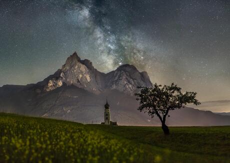 ie Kirche von Seis mit den Dolomiten im Hintergrund und Polarlichtern am Himmel