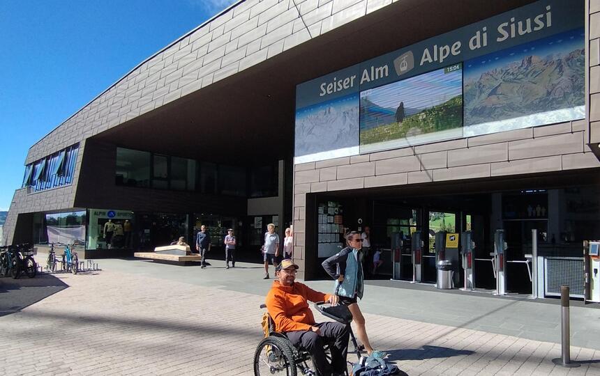 Ein Mann im Rollstuhl vor der Umlaufbahn zur Seiser Alm