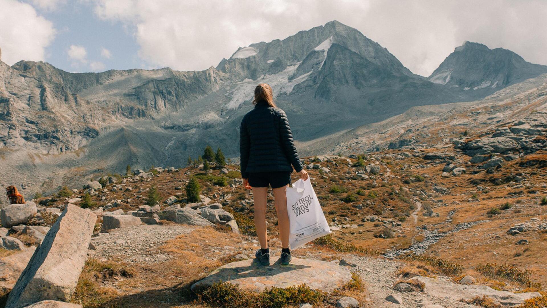 Eine Frau sammelt Müll in den Bergen