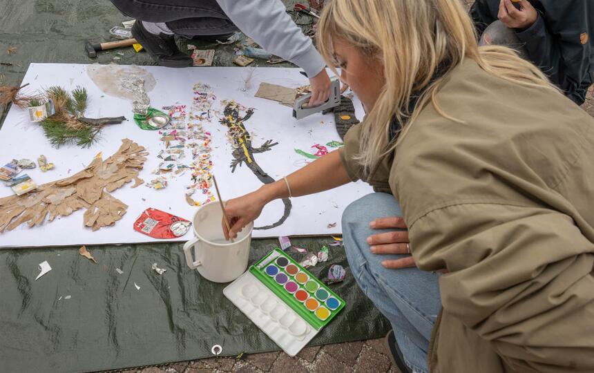 Eine Gruppe von Personen malt ein Bild mit Naturmaterialien