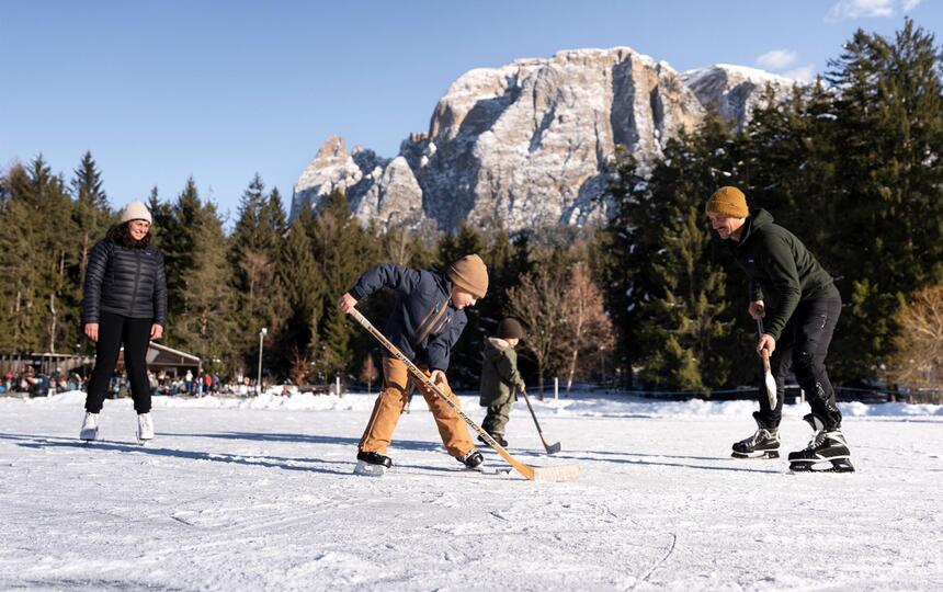 Eine Familie mit zwei Kindern spielt Eishockey
