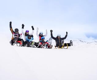Eine Gruppe von Personen beim Rodeln