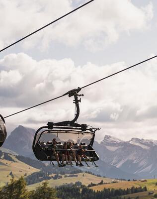 Vier Personen fahren mit dem Sessellift