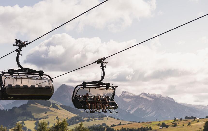 Vier Personen fahren mit dem Sessellift